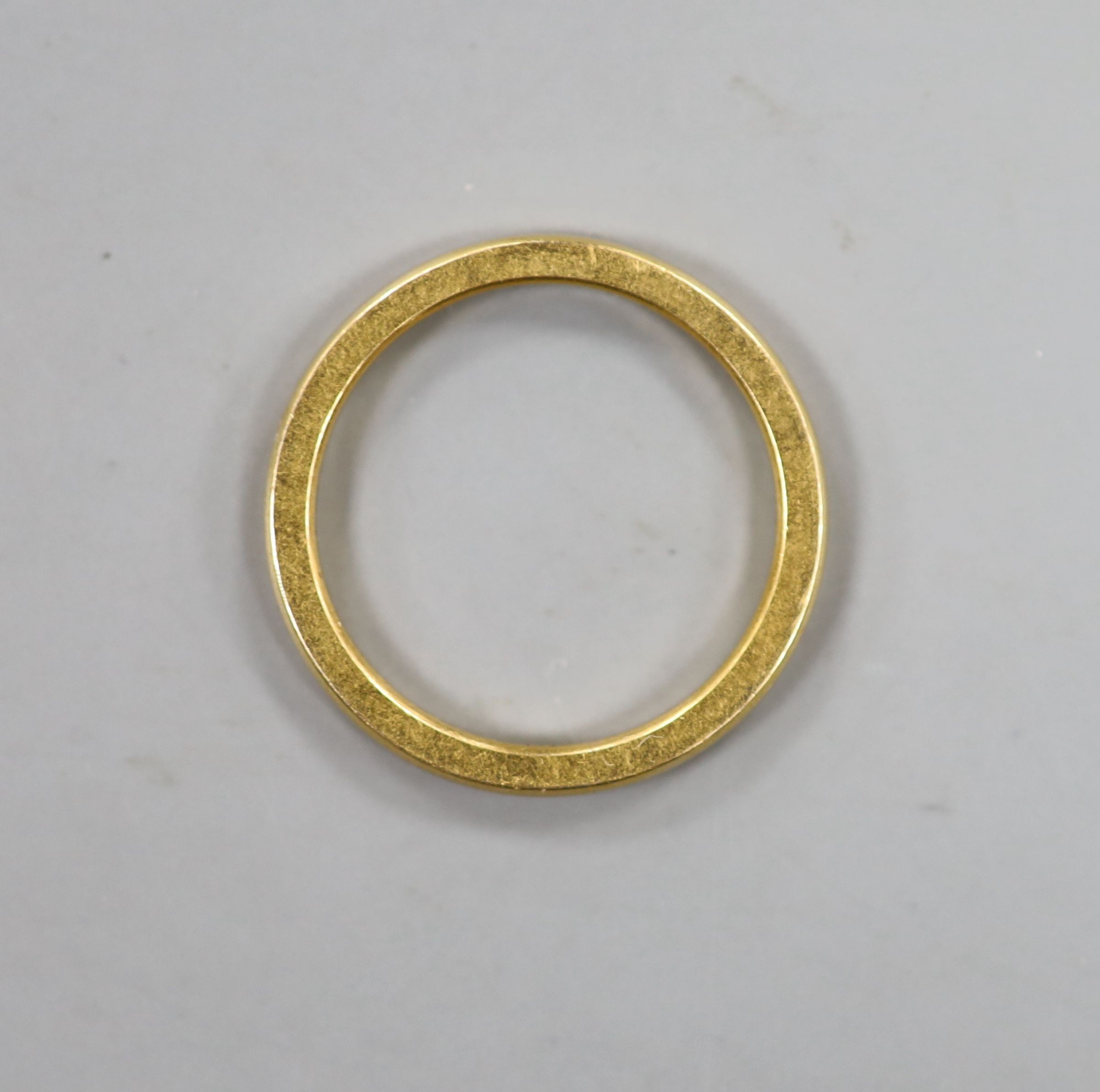 A 22ct gold wedding band, with indistinct latin? inscription to the shank, size M/N, 3.5 grams.